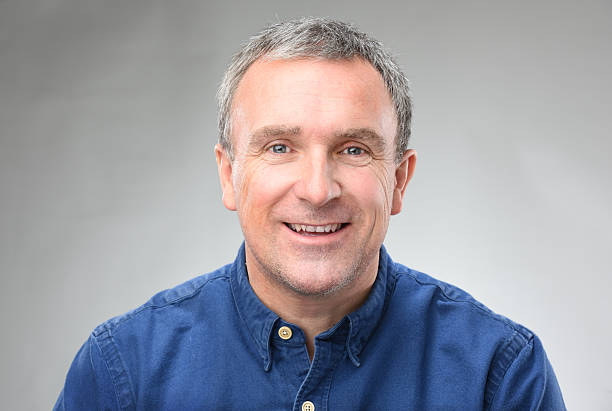 Our Team a heads and shoulders shot of a smiling man in his late 40s .